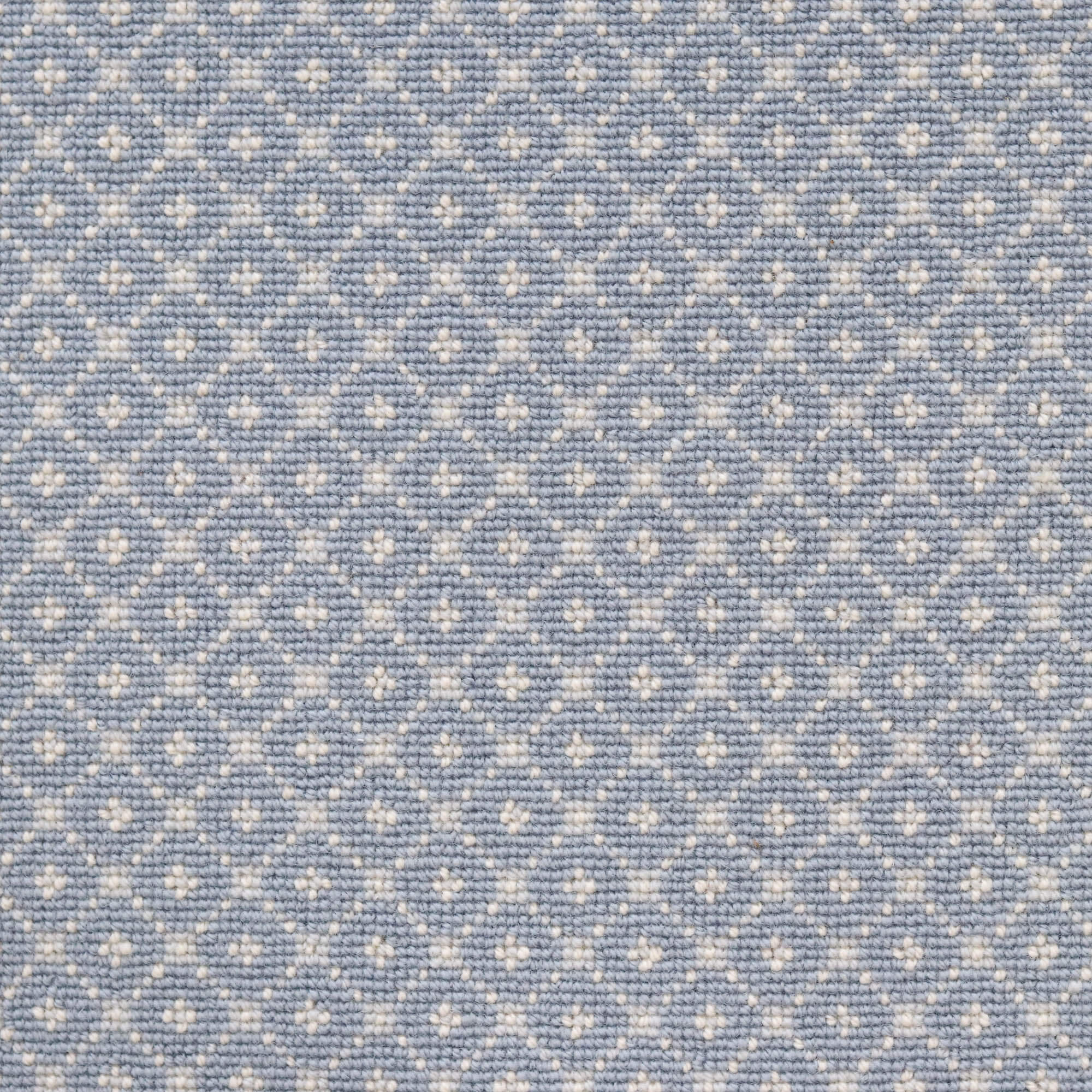 Broadloom carpet with dotted lattice in cream on a sky blue field. 