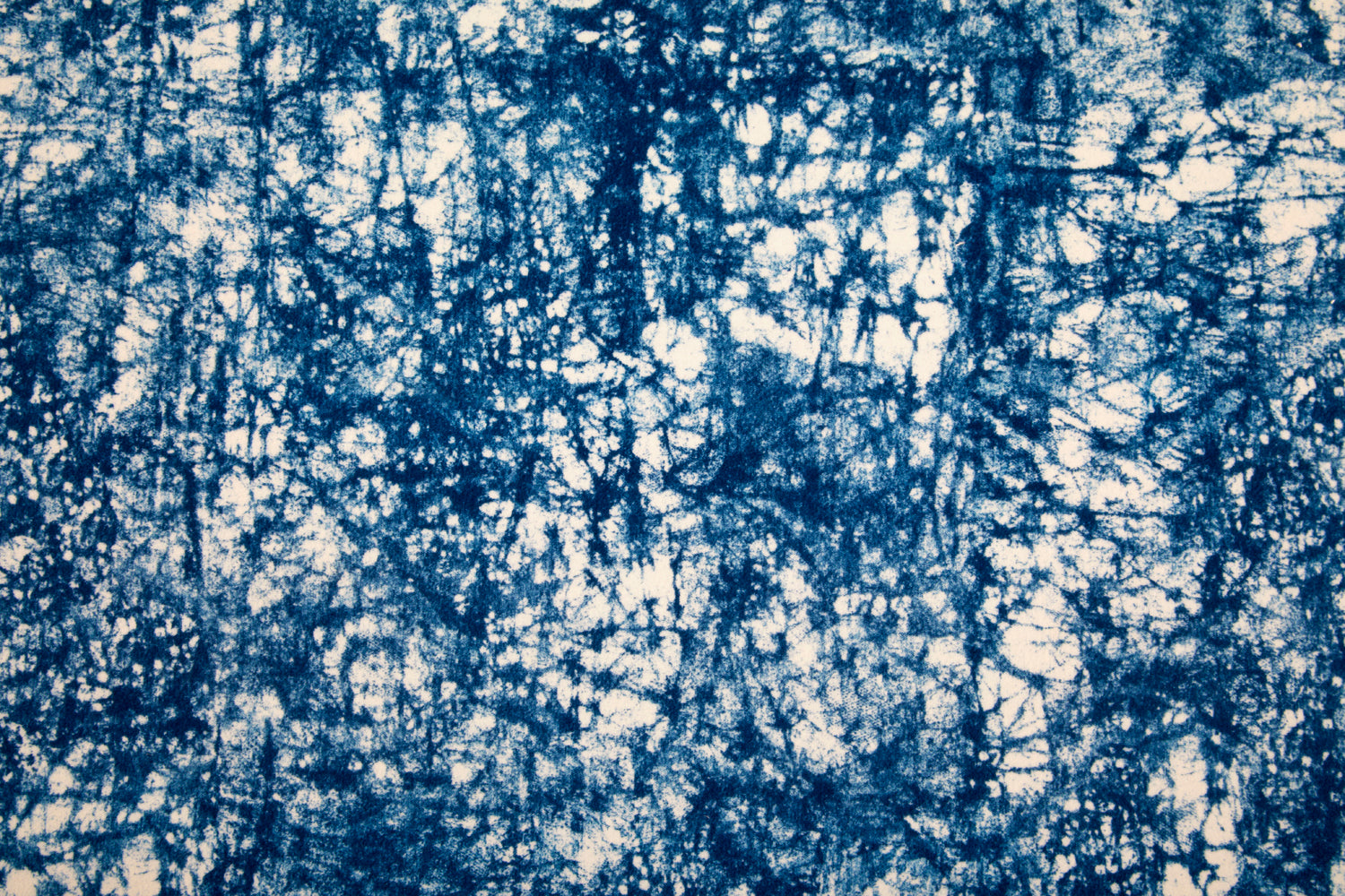Detail of velvet fabric in an organic crumpled texture in navy on a cream field.