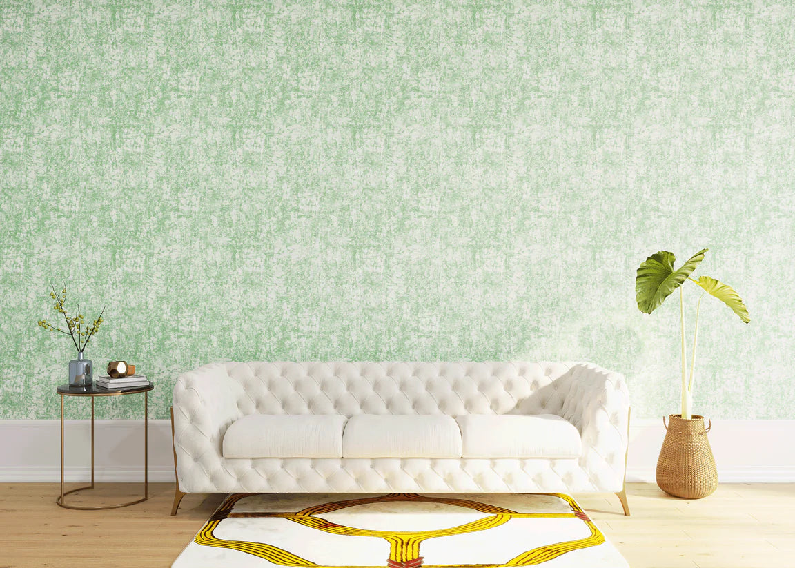 Styled living room tableau with a wall papered in an organic textural print in light green on a white field.