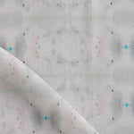 Detail of draped fabric yardage in a repeating ink blot print in shades of gray with turquoise and pink accents.
