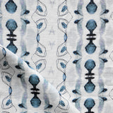 Detail of draped fabric yardage in a watercolor ikat stripe print in shades of blue and black on a white field.