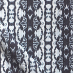 Detail of draped fabric yardage in a watercolor ikat stripe print in shades of white and blue on a gray field.