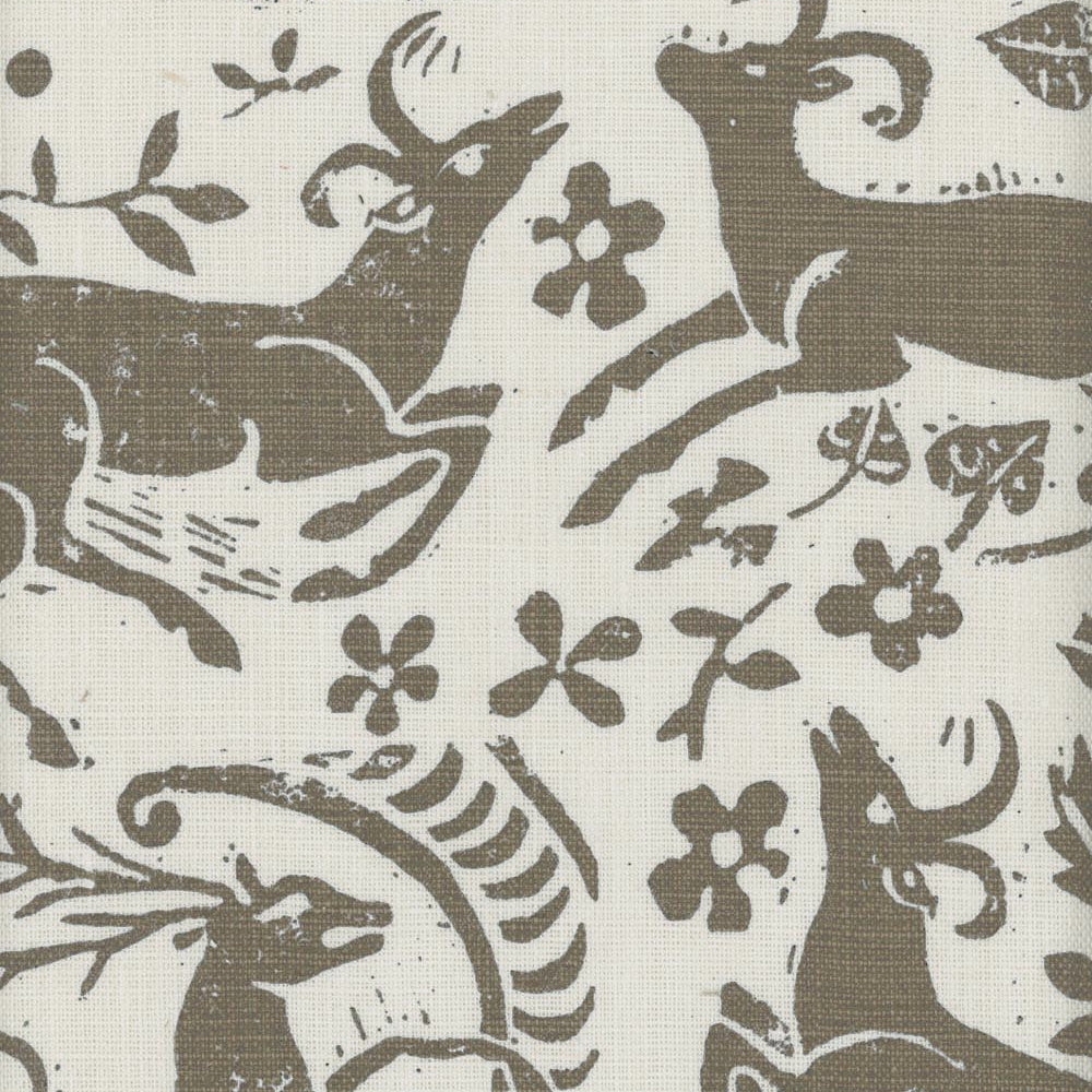 Close-up of fabric in a deer, leaf and flower print in taupe on a cream field.
