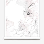 Partially unrolled wallpaper yardage in a painterly floral print in shades of pink and charcoal on a white field.