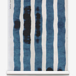 Grasscloth Wallpaper roll with bold watercolor stripes in greige and white on a white background.