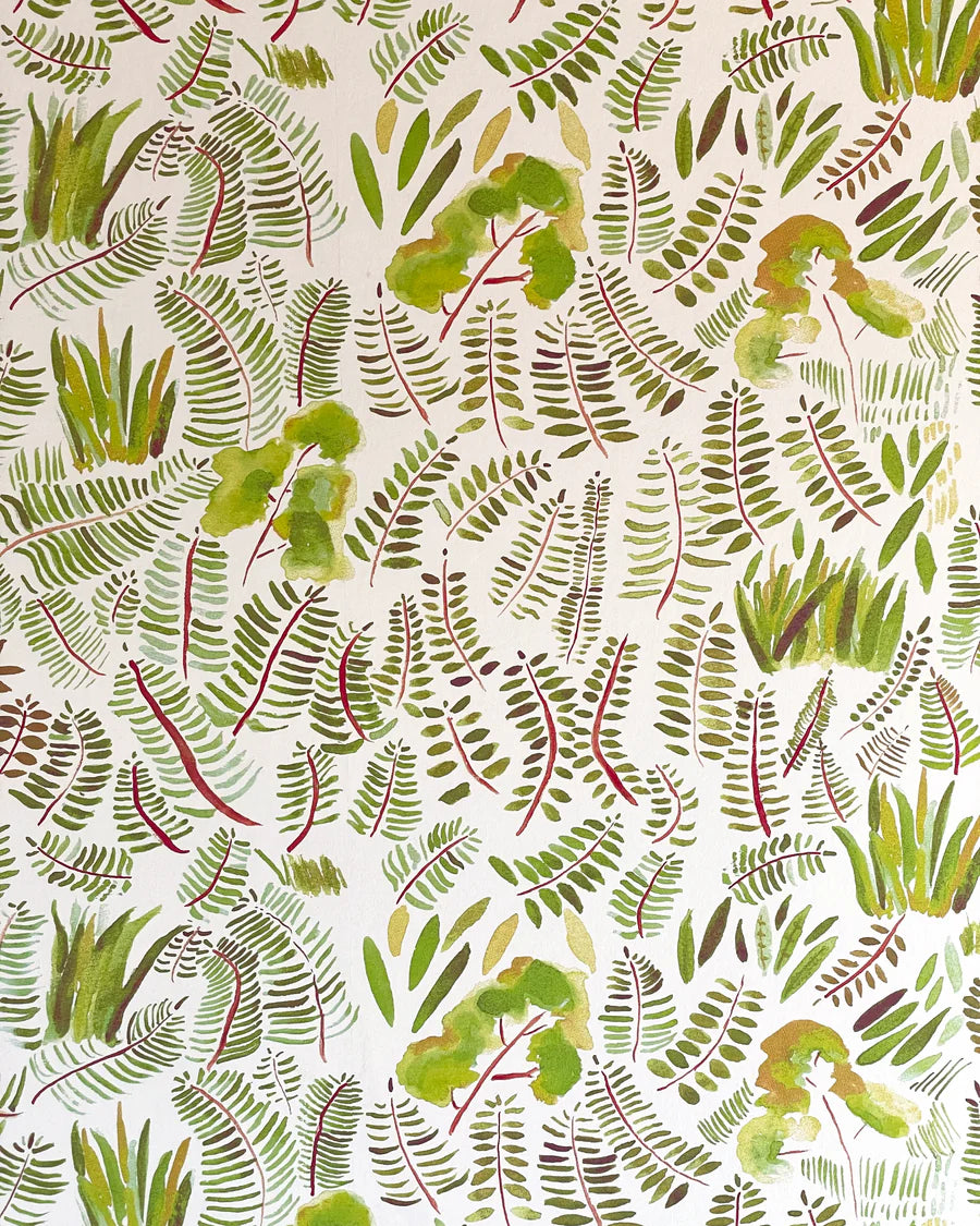 Detail of wallpaper in a playful leaf print in shades of green and red on a cream field.