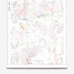 Partially unrolled wallpaper yardage in a watercolor painterly print in shades of pastel, green and cream.