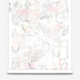 Partially unrolled wallpaper yardage in a watercolor painterly print in shades of pastel, green and cream.