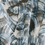 Draped fabric yardage in an absract paint swatch print in black and navy on a white field.