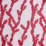 Detail of fabric in a dimensional embroidered botanical print in red on a white field.