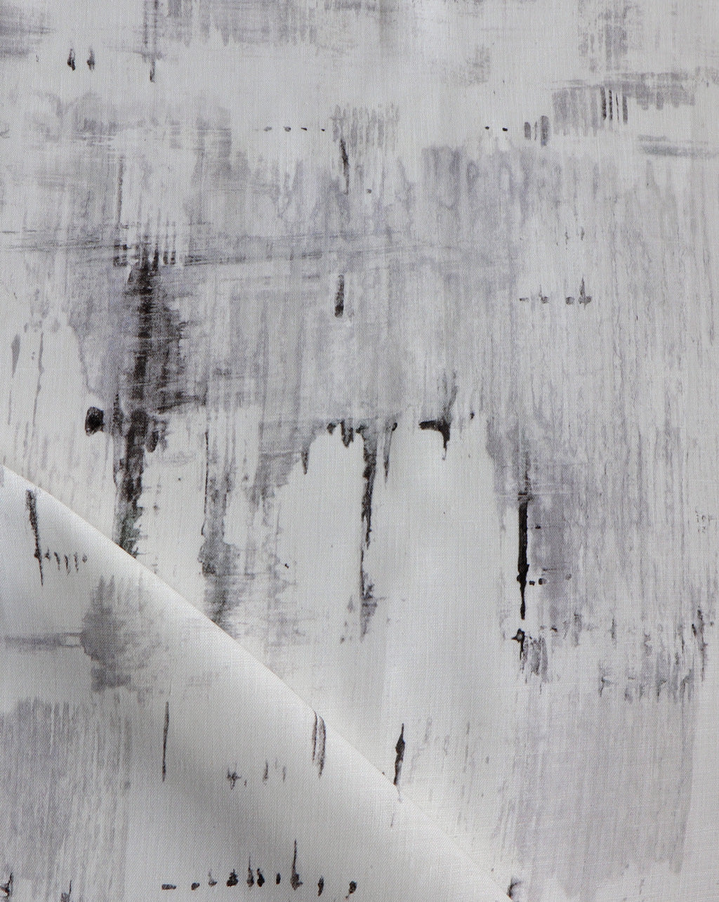 Detail of fabric in a watercolor paint blot print in black and gray on a white field.