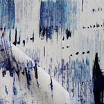 Detail of fabric in a watercolor paint blot print in blue on a white field.