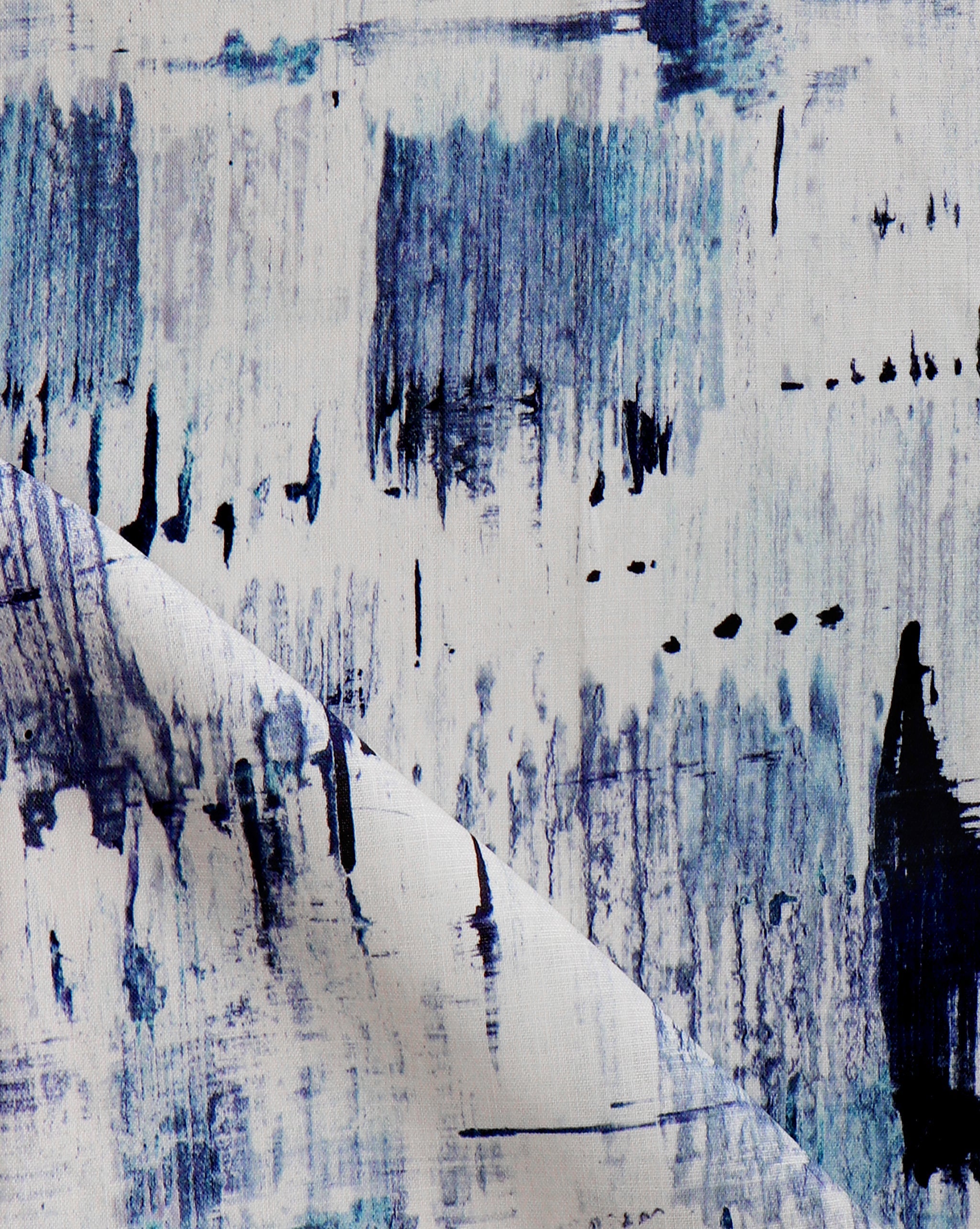 Detail of fabric in a watercolor paint blot print in blue on a white field.