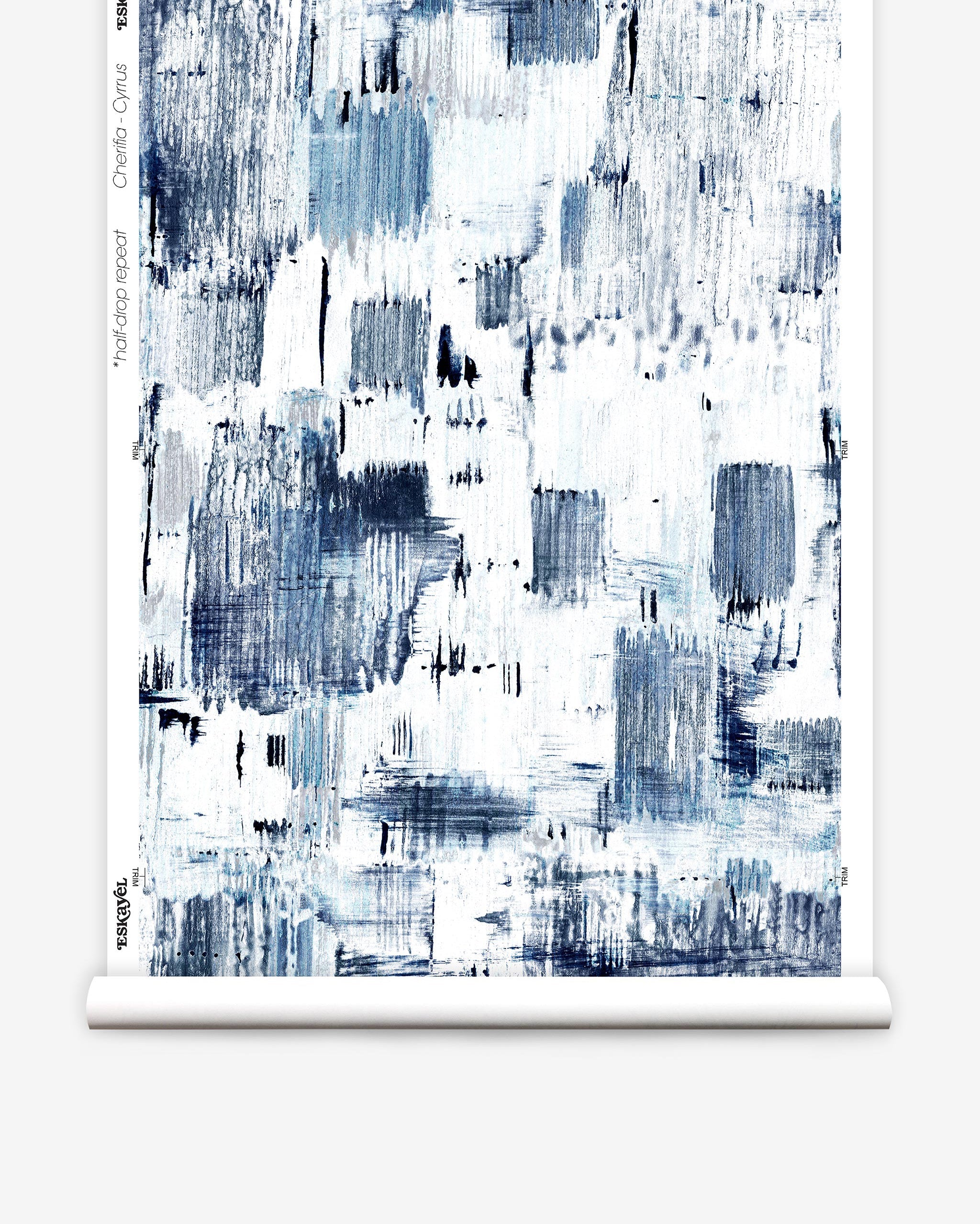 Partially unrolled wallpaper yardage in a watercolor textural print in shades of navy and blue on a white field.