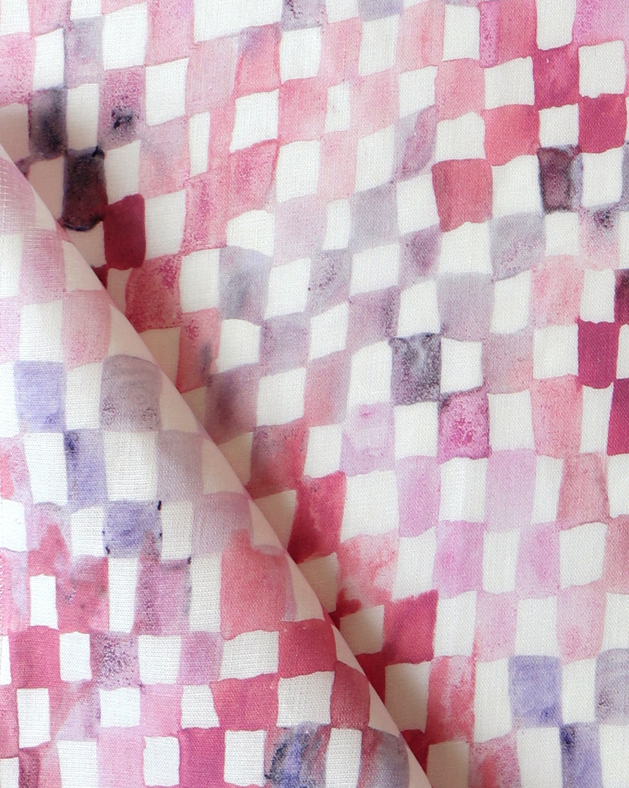 Detail of fabric in a painterly check pattern in shades of pink and purple on a white field.