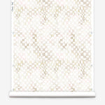 Partially unrolled wallpaper yardage in a painterly chess board print in shades of cream on a white field.