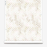 Partially unrolled wallpaper yardage in a painterly chess board print in shades of cream on a white field.