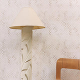 A modernist living tableau with a wall papered in a painterly chess board print in shades of cream and white.