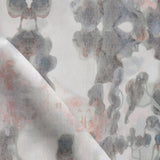 Detail of fabric in a watercolor tree print in shades of pink and gray on a greige field.
