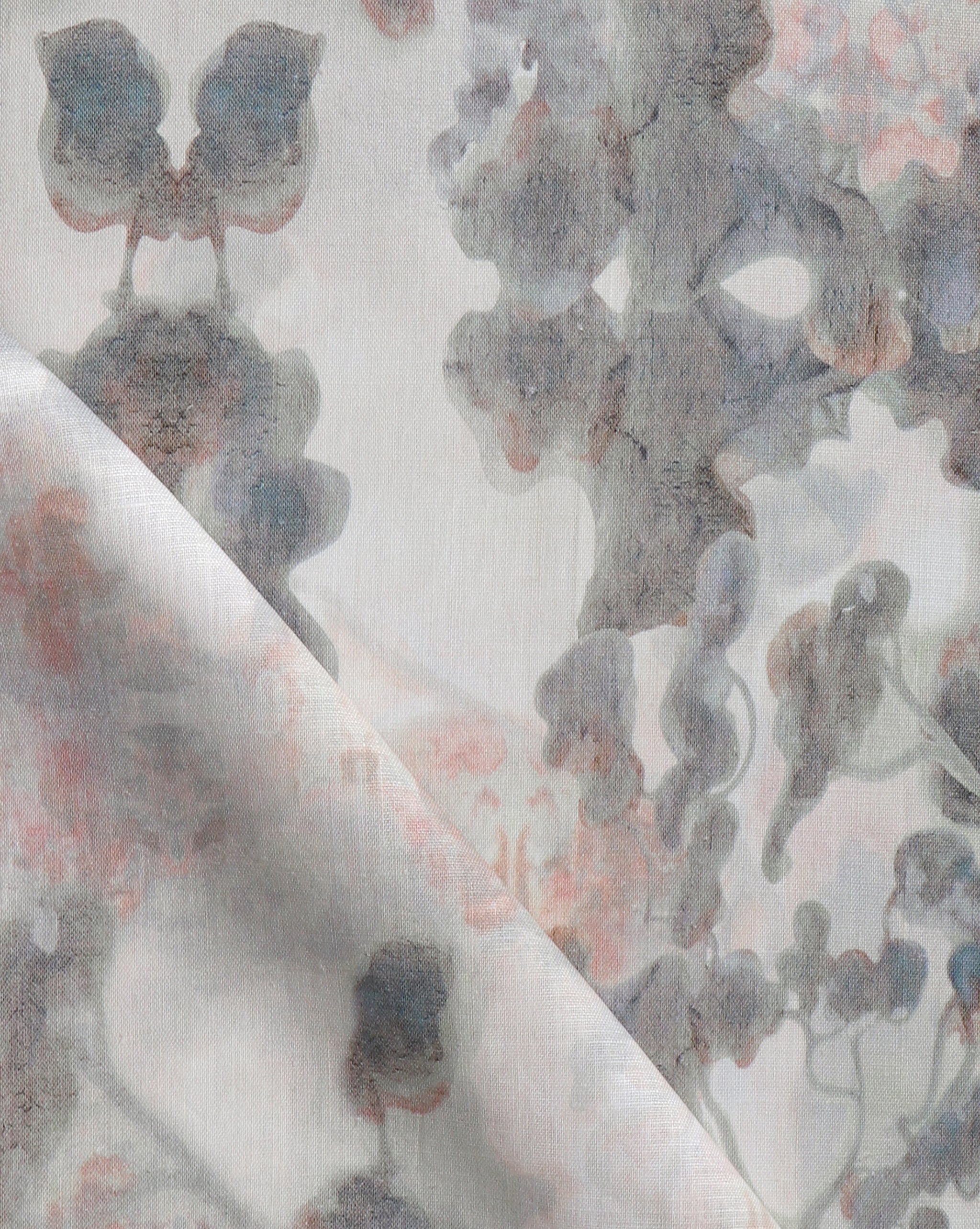 Detail of fabric in a watercolor tree print in shades of pink and gray on a greige field.