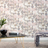 A modernist living tableau with a wall papered in a watercolor tree print in gray, peach, tan and white.