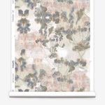 Partially unrolled wallpaper yardage in a watercolor tree print in gray, peach, tan and white.