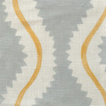 Close-up of fabric in a playful curvy stripe print in white and yellow on a light blue field.