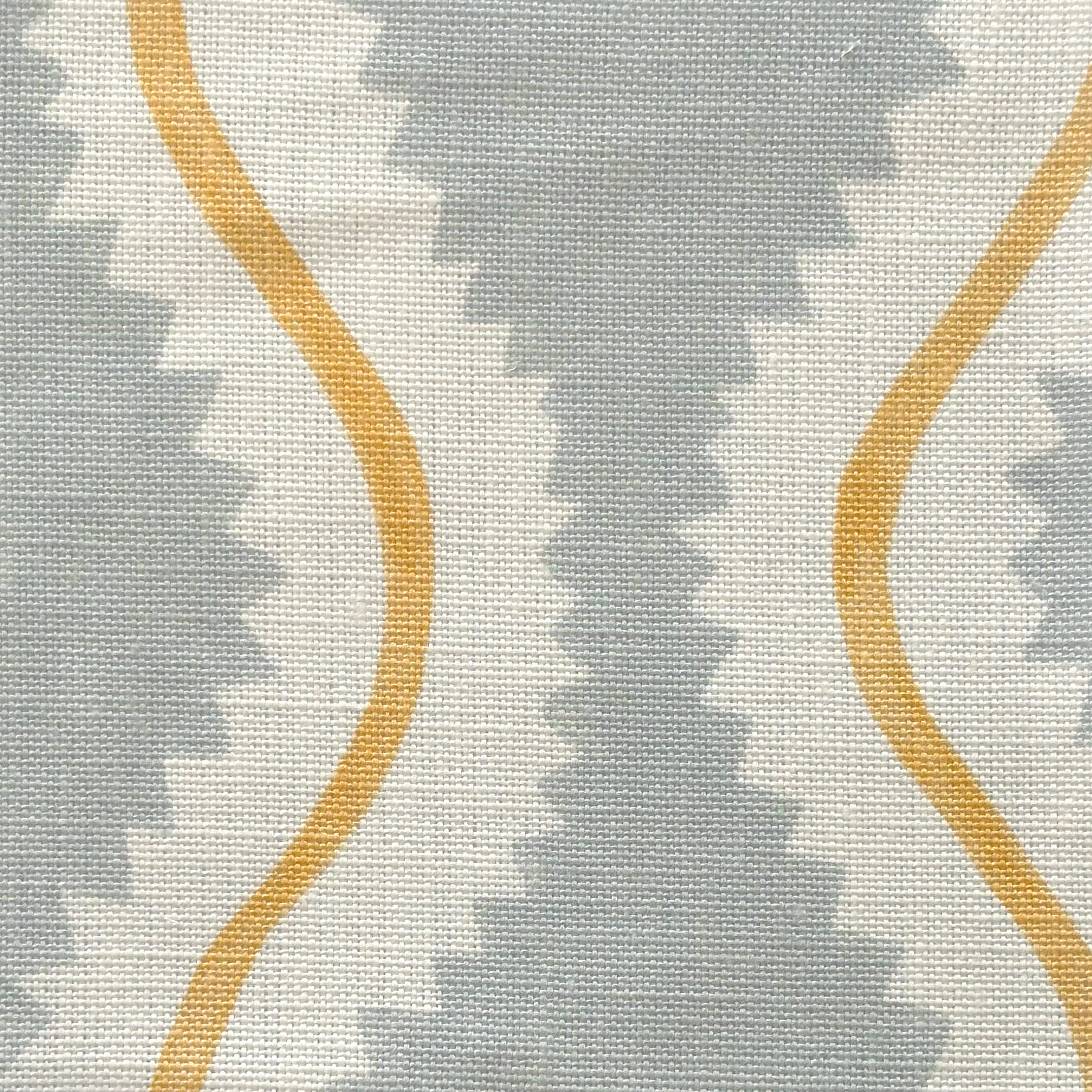 Close-up of fabric in a playful curvy stripe print in white and yellow on a light blue field.