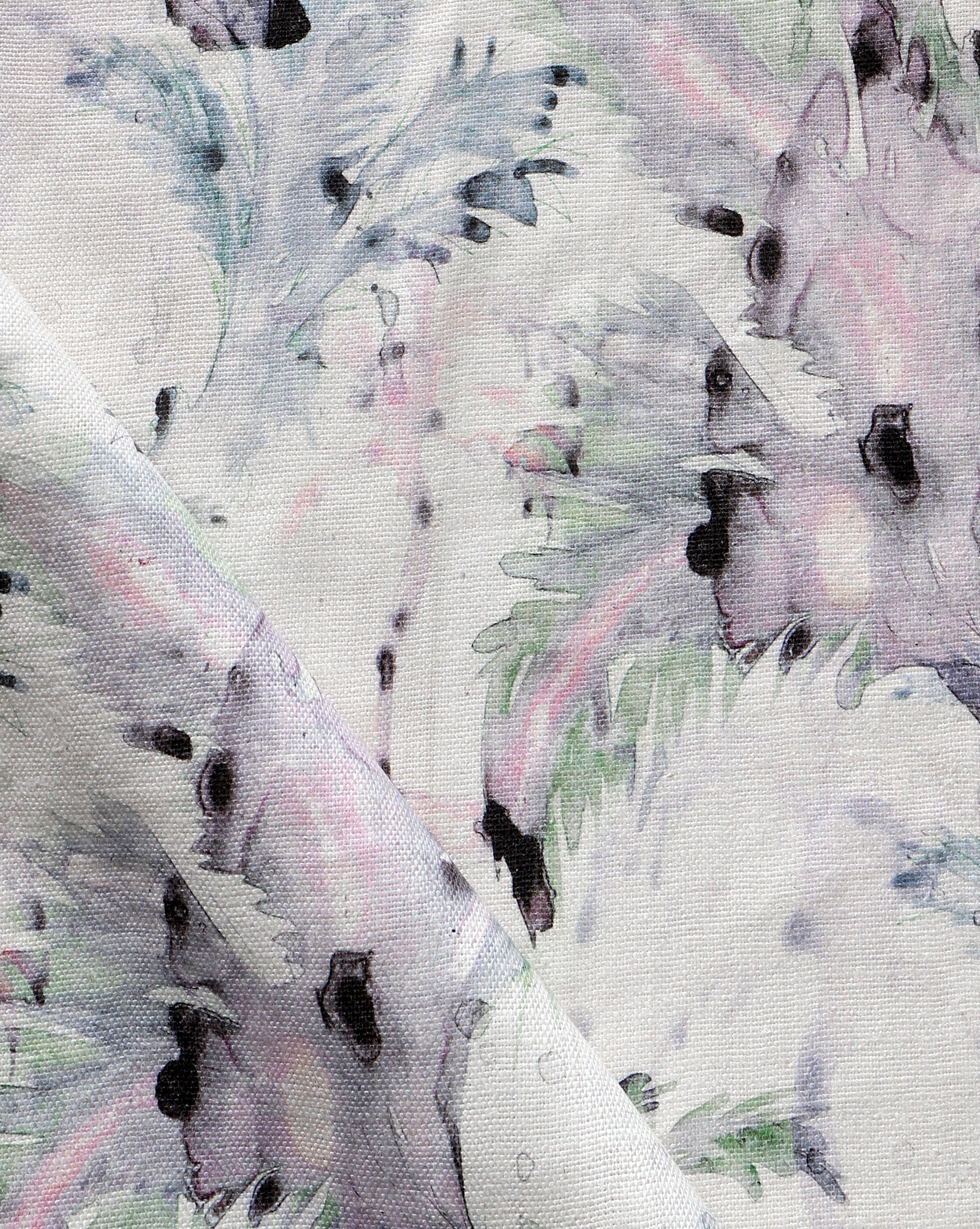 Detail of fabric in a painterly palm leaf print in shades of green, purple and gray on a cream field.