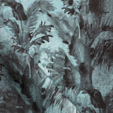 Detail of fabric in a painterly palm leaf print in shades of turquoise and gray.