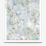 Partially unrolled wallpaper yardage in a watercolor painted print in shades of blue, green, yellow and white.