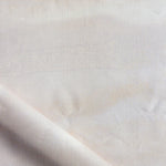 Close-up of a textured white fabric with a subtle pattern