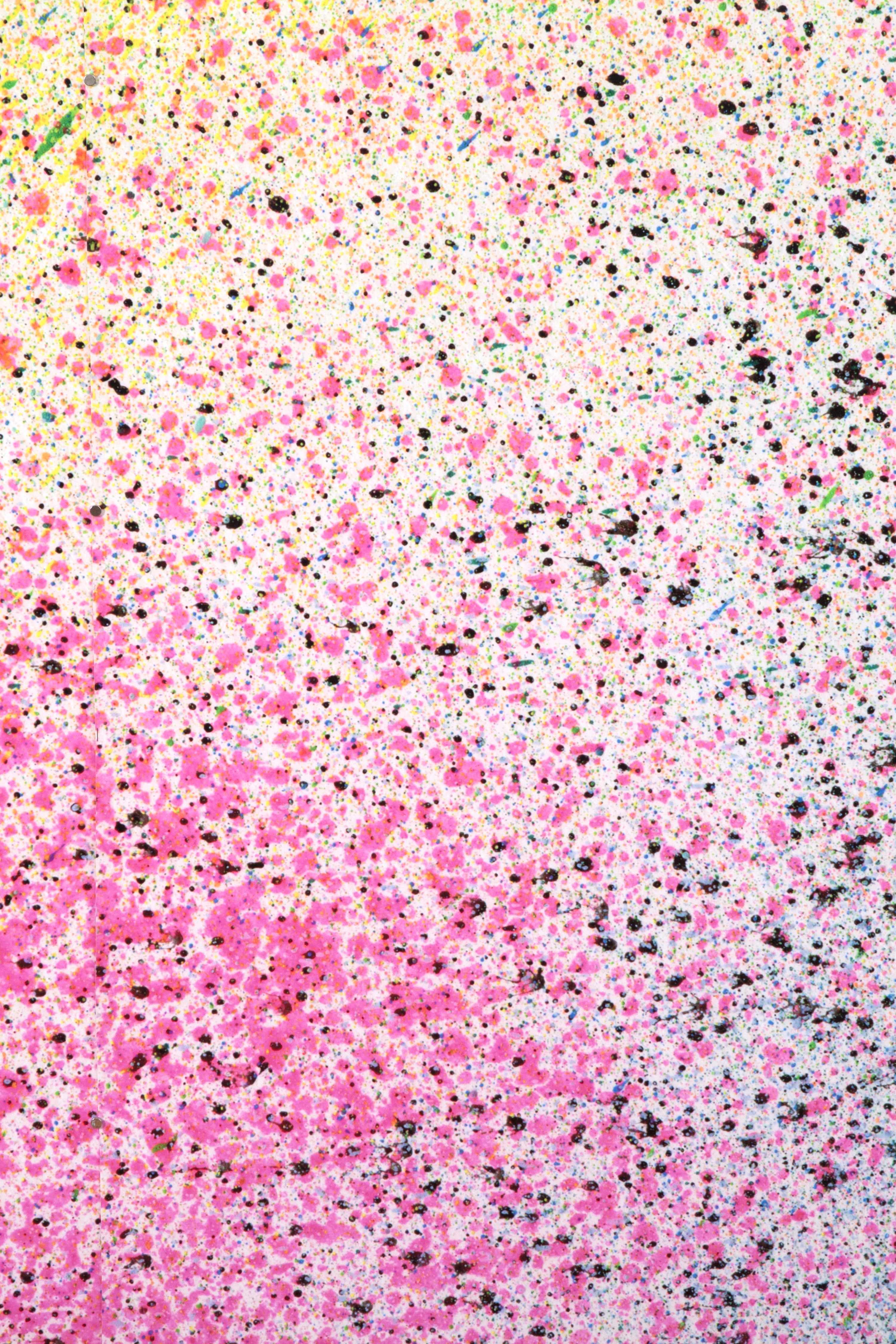 Close up of paint splatters in pink, black and yellow.
