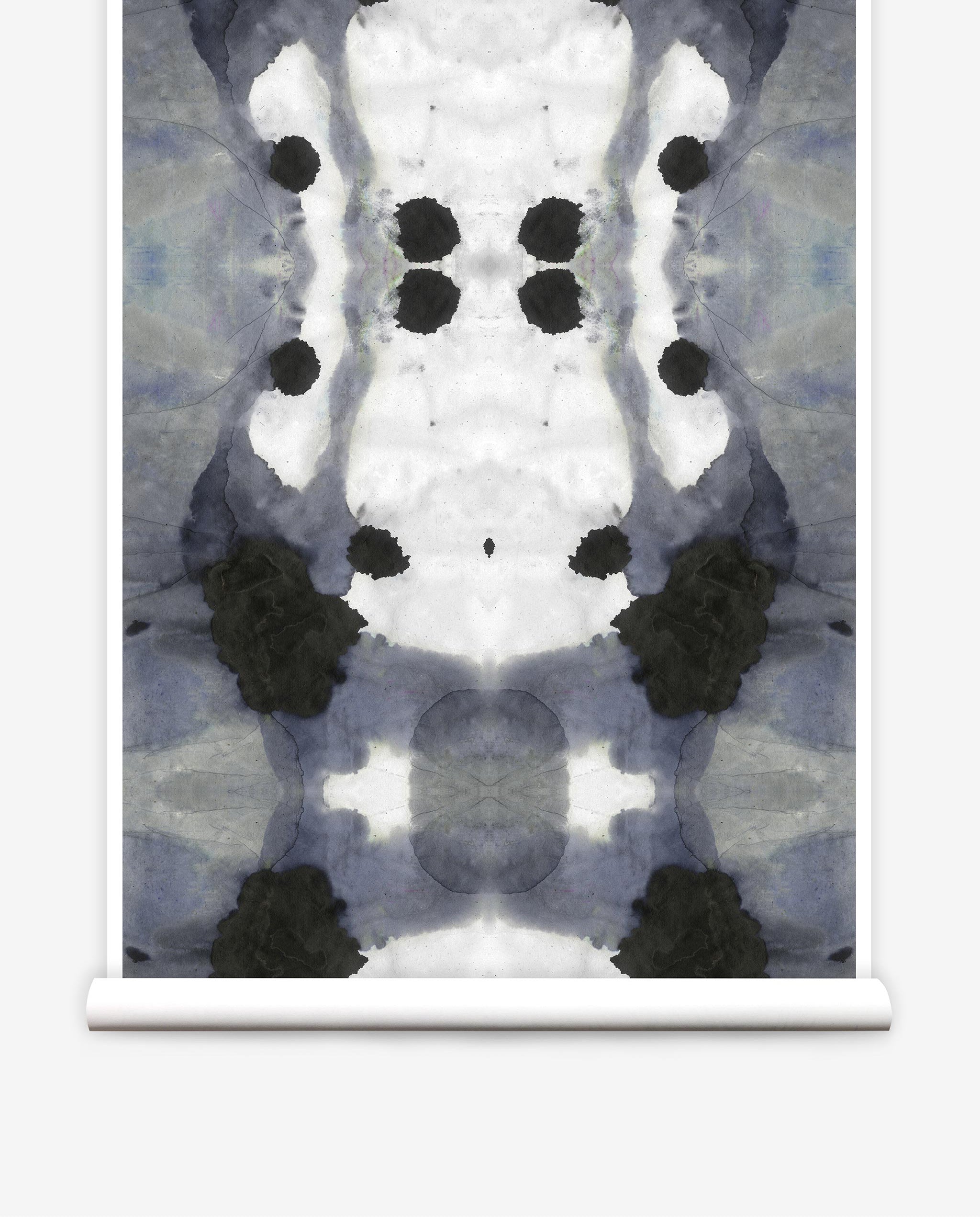 Partially unrolled wallpaper yardage in a watercolor ink blot print in charcoal, gray and white.