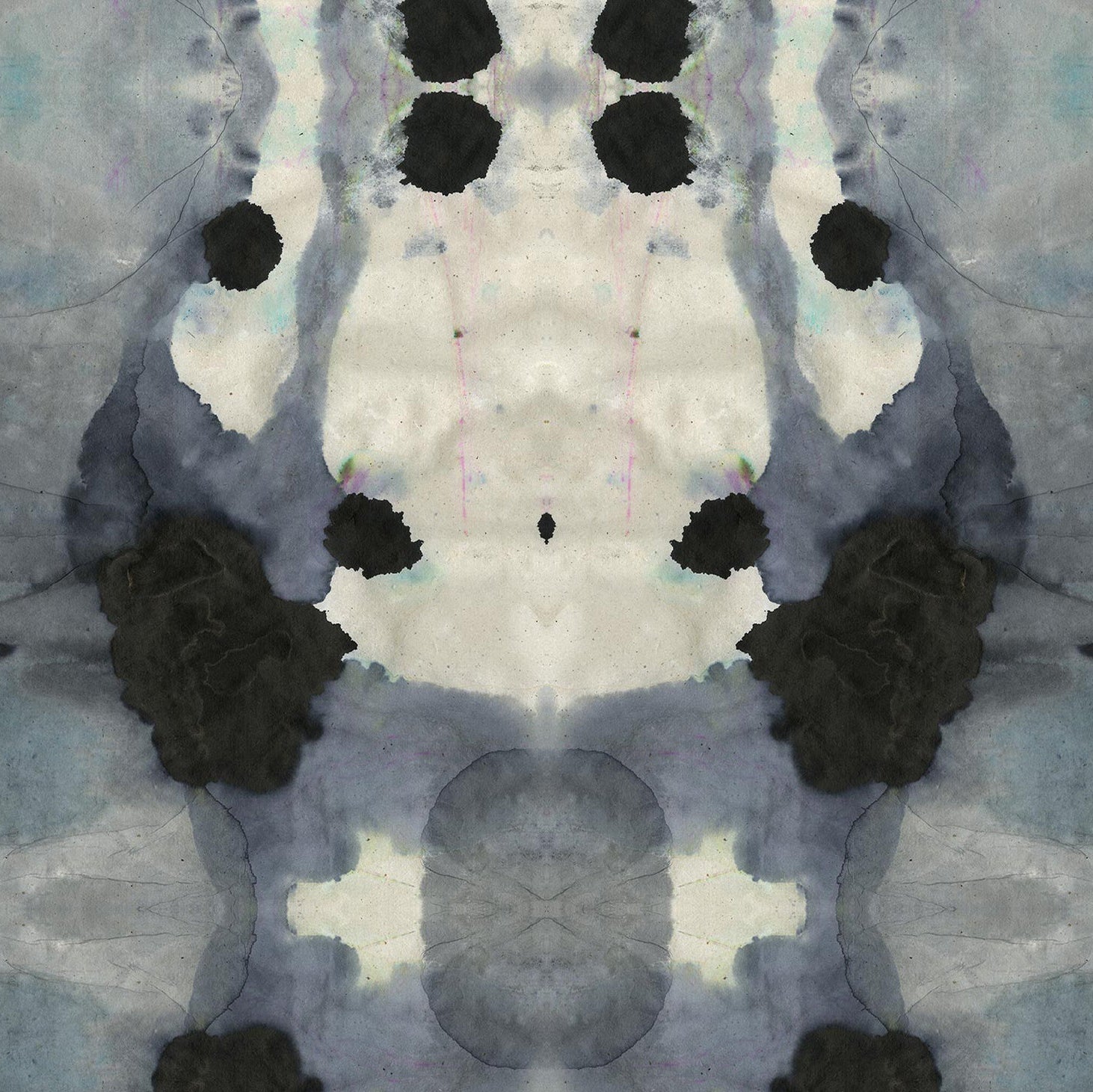 Close-up of wallpaper in a watercolor ink blot print in shades of charcoal and gray on a tan field.