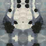 Close-up of wallpaper in a watercolor ink blot print in shades of charcoal and gray on a tan field.