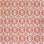 Detail of fabric in a floral grid print in cream on a coral field.