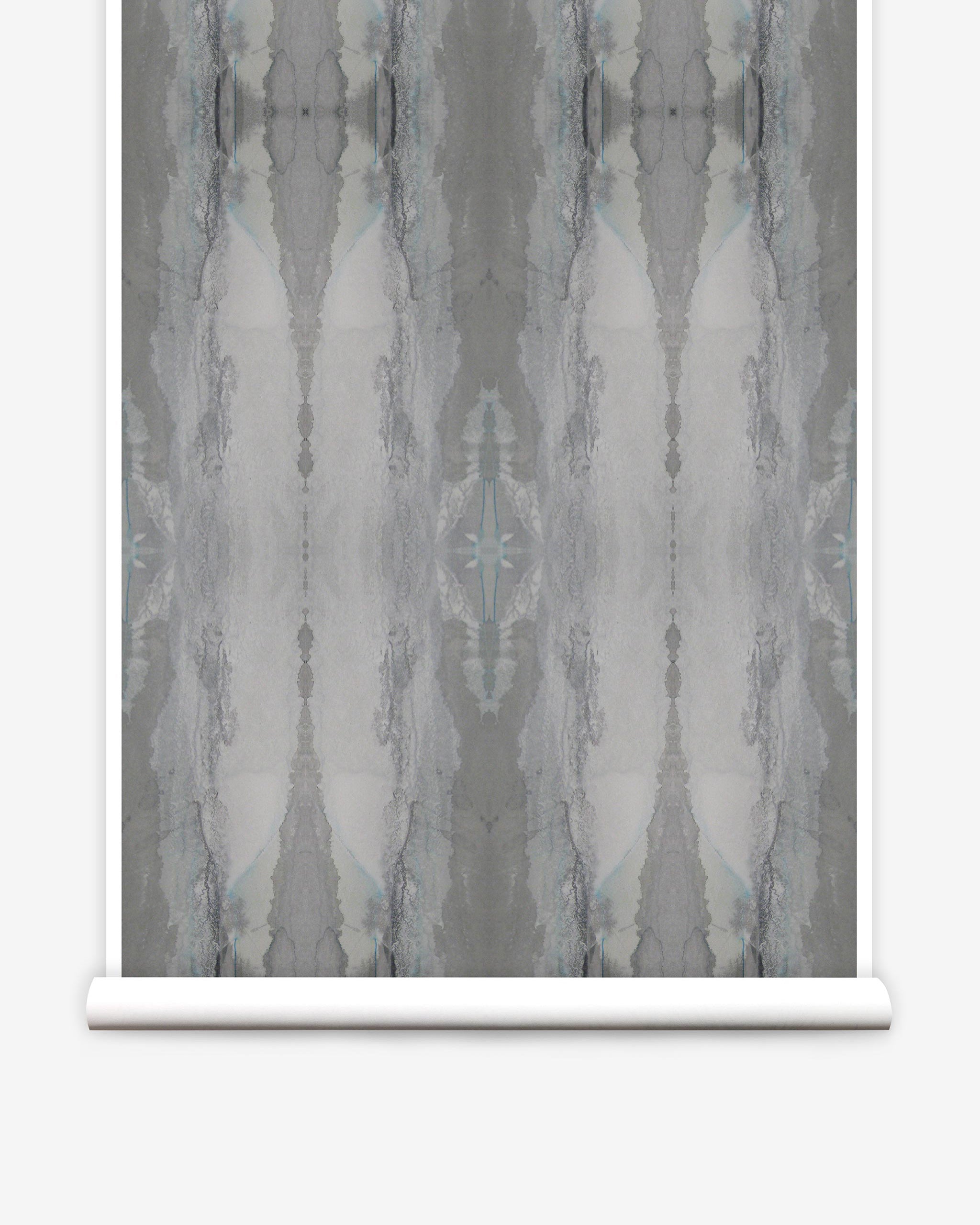 Partially unrolled wallpaper yardage in a watercolor textural print in shades of gray.