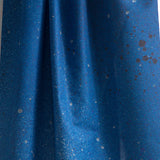 Draped fabric yardage in an abstract ombré paint splatter print in shades of blue and gray.