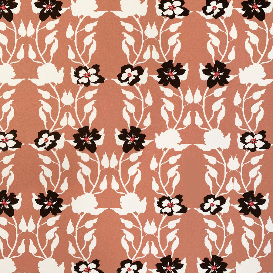 Detail of wallpaper in a linear floral print in red, white and black on an orange field.