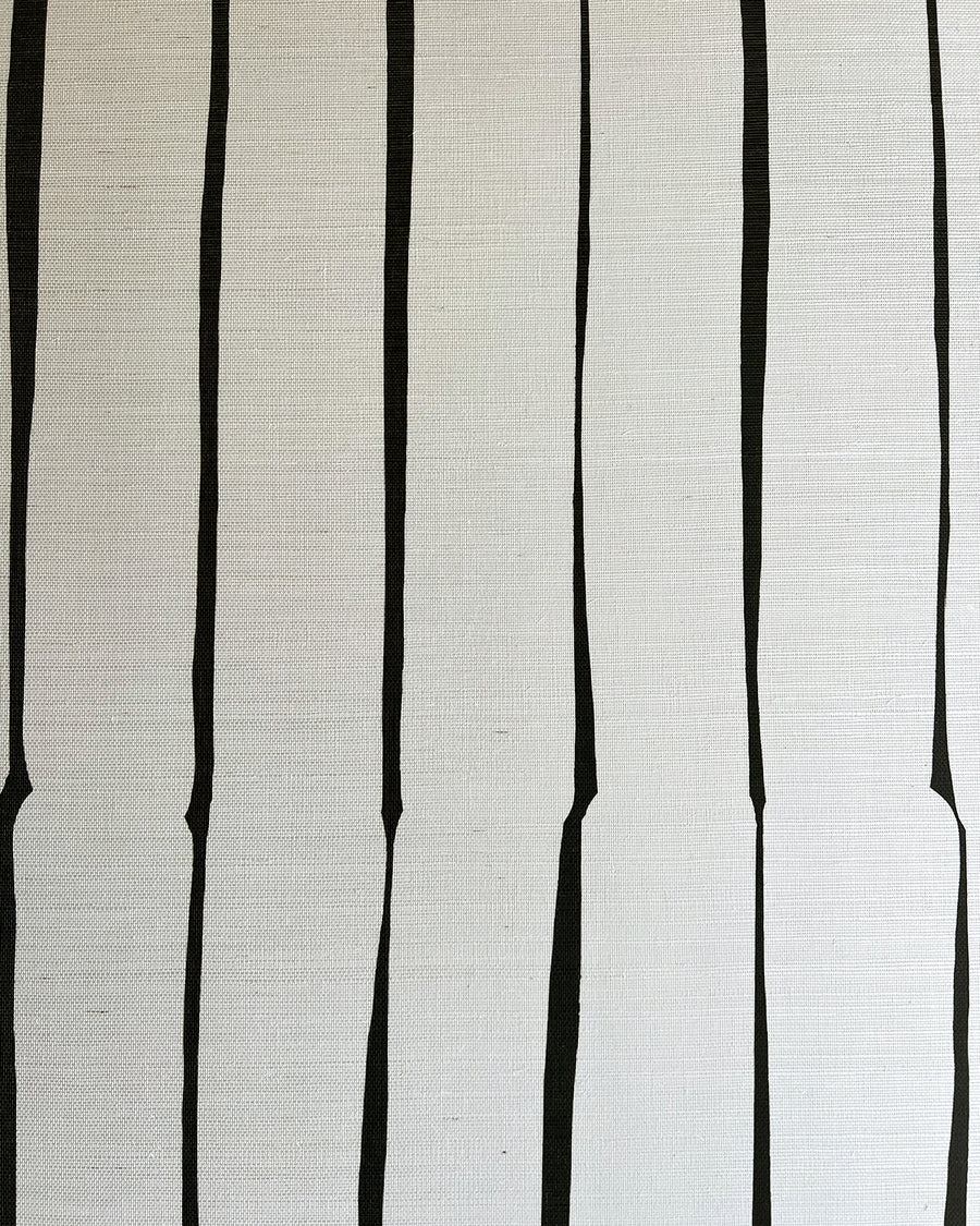 Detail of fabric in a playful irregular stripe print in black on a cream field.