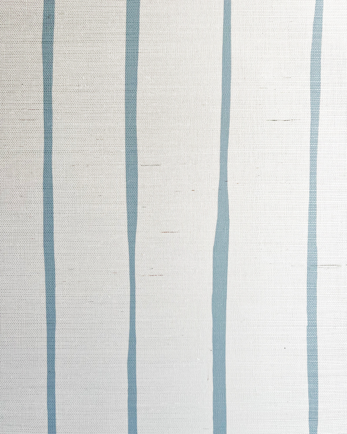 Detail of fabric in a playful irregular stripe print in blue on a cream field.