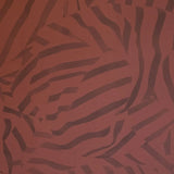 Detail of wallpaper in a playful broken stripe print in purple on a red field.