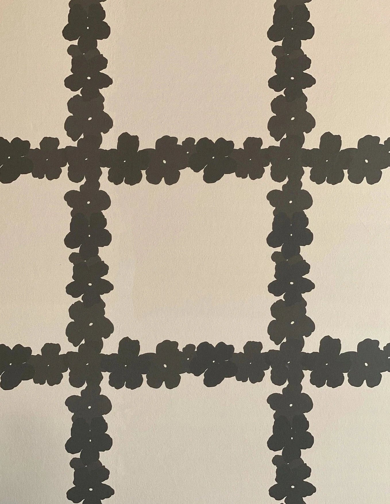 Detail of wallpaper in a floral grid print in brown on a white field.