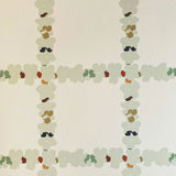 Detail of wallpaper in a floral grid print in cream, green and pink on a white field.