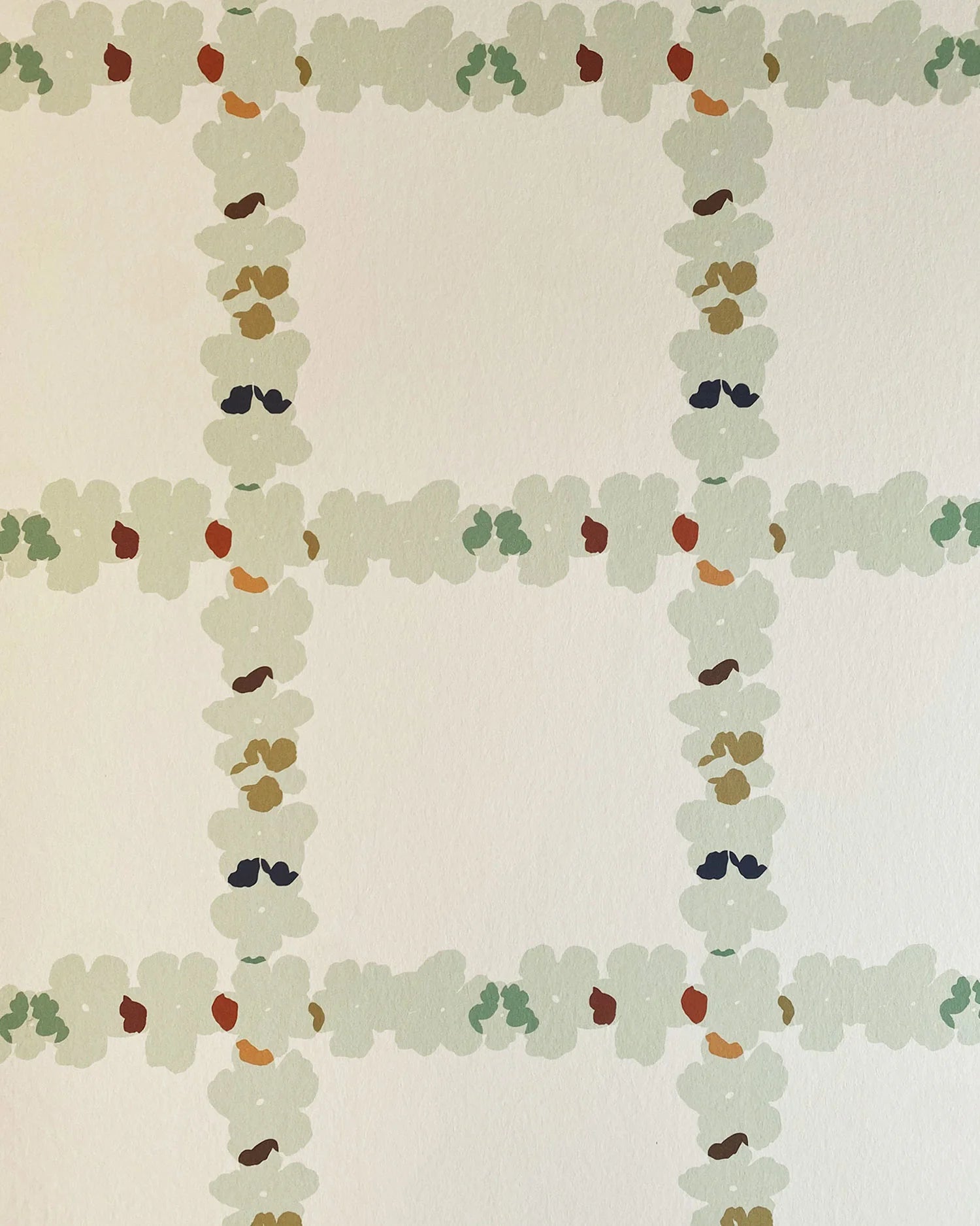 Detail of wallpaper in a floral grid print in cream, green and pink on a white field.