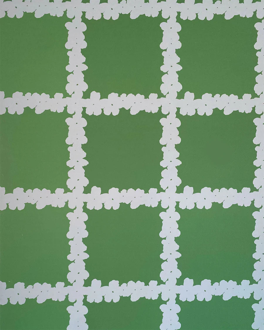 Detail of wallpaper in a floral grid print in white on a green field.