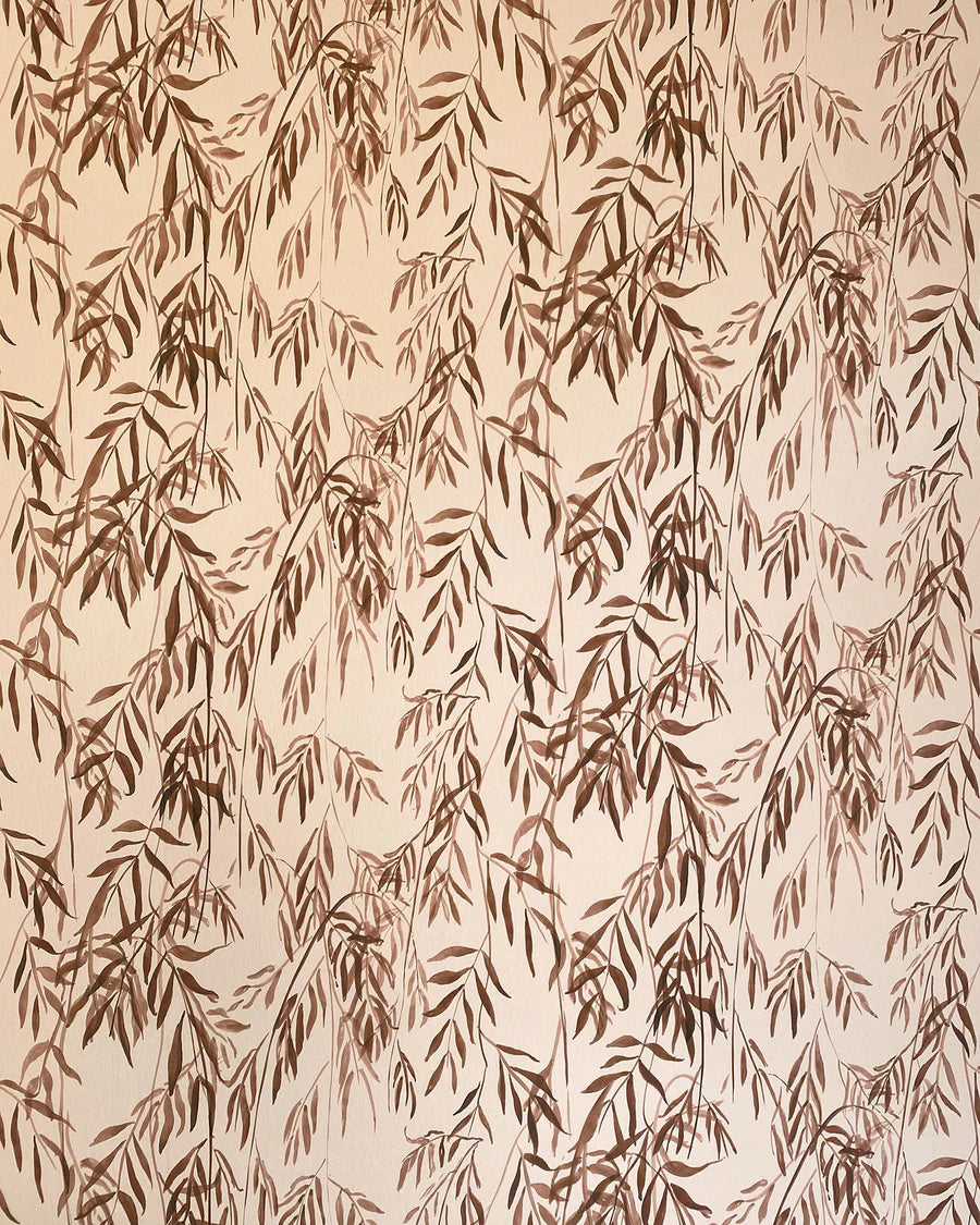 Detail of wallpaper in a painterly willow leaf print in brown on a cream field.