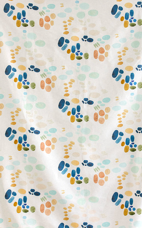 Detail of fabric in an abstract painterly print in shades of turquoise, blue and orange on a white field.