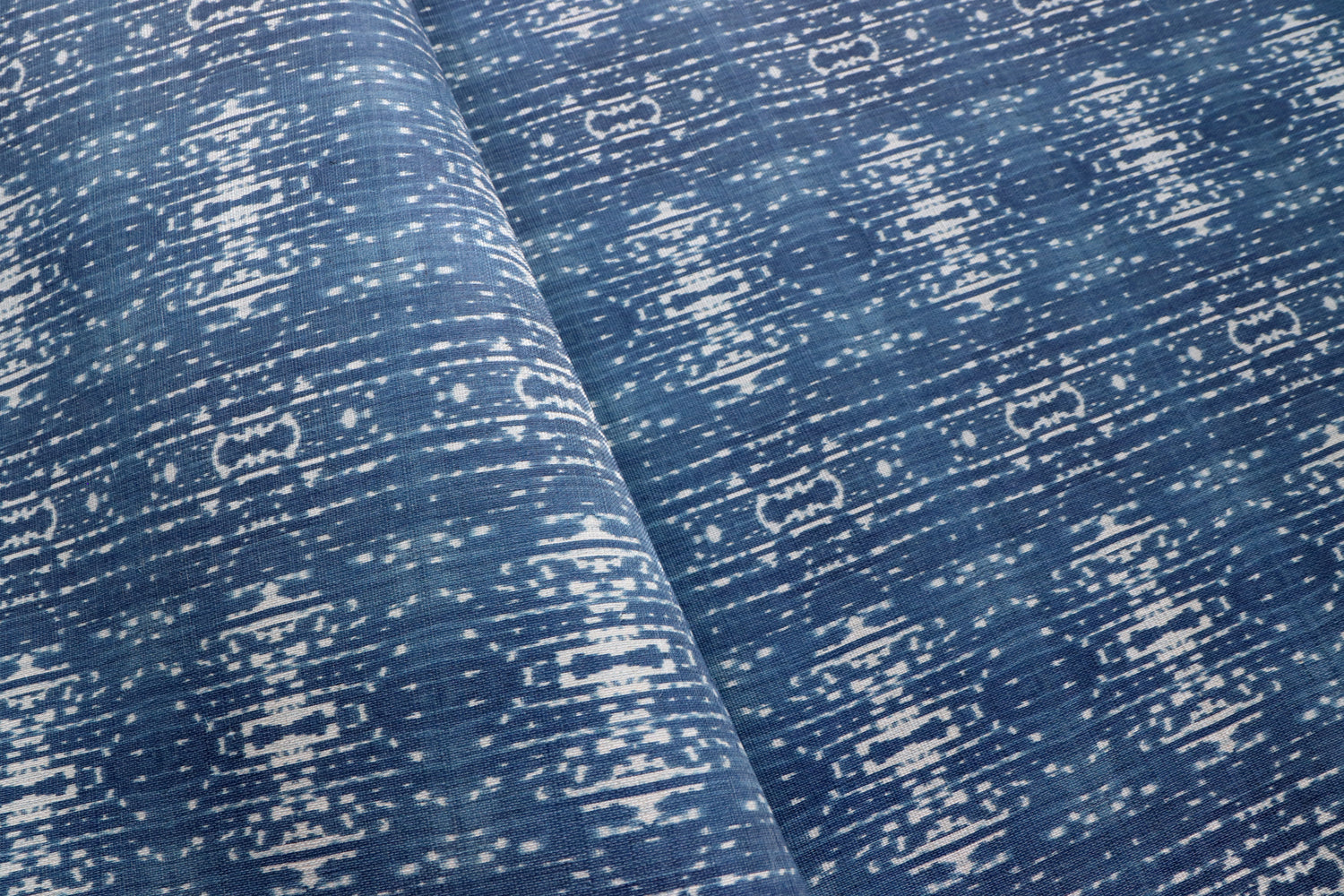 Close up of printed grasscloth with ikat stripe design in blue and cream 